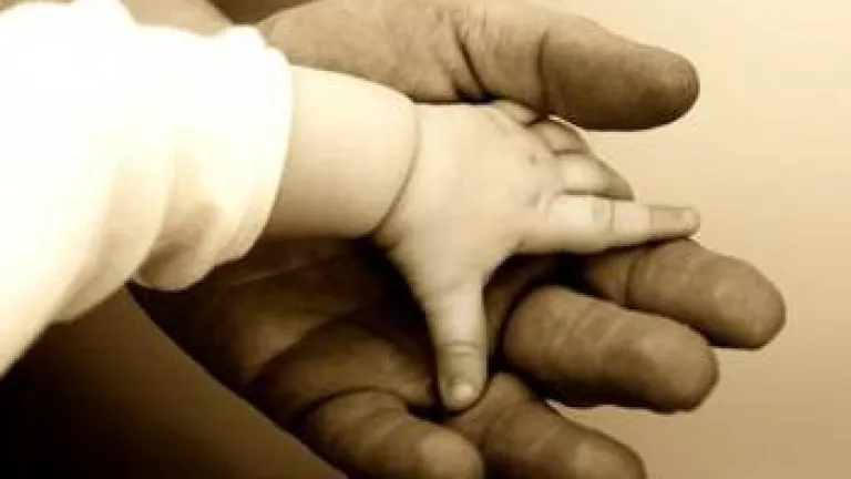 Baby hand on top of a big hand - God's Family: The Reason You Were Born