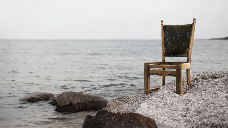 A chair sitting by a lake.