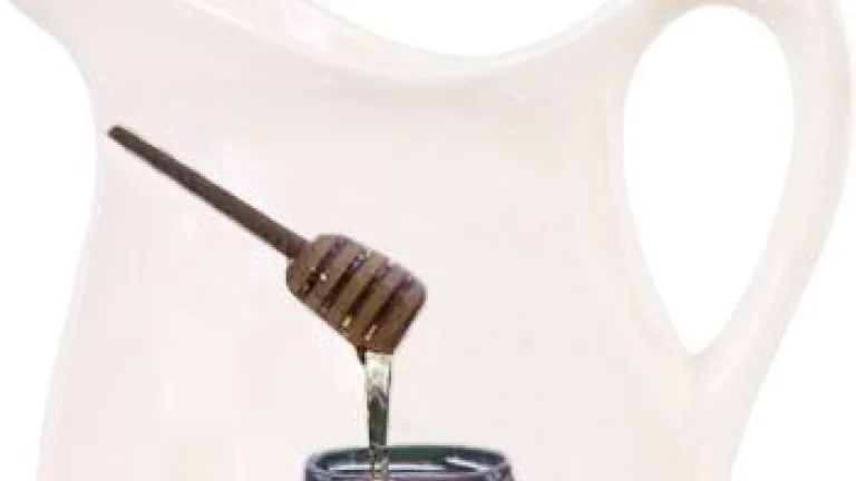 Old milk jar with a honey jar in front.