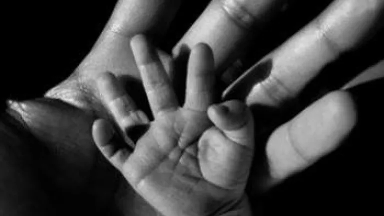 baby hand next to adult hand