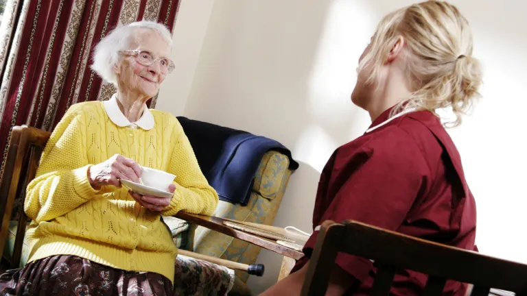A young woman visiting with an elderly lady.