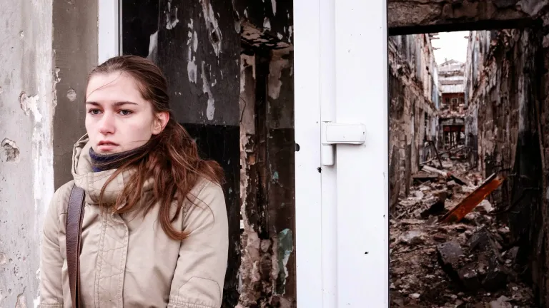 A young woman waits outside a building in Kurakhove, Eastern Ukraine, shattered in the conflict between pro- and anti-Russian fighters. A young woman waits outside a building in Kurakhove, Eastern Ukraine.