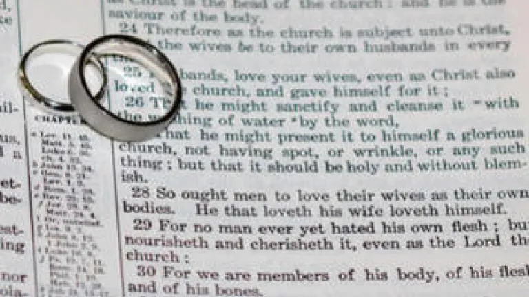 The Ultimate Purpose of Marriage Wedding rings on top of Bible scripture - Ephesians 5:22-21