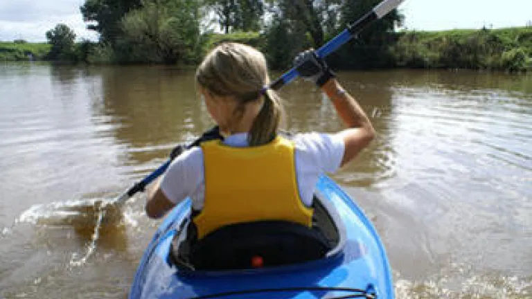 This Woman's Walk: Paddle Accordingly A woman paddling a kayak.