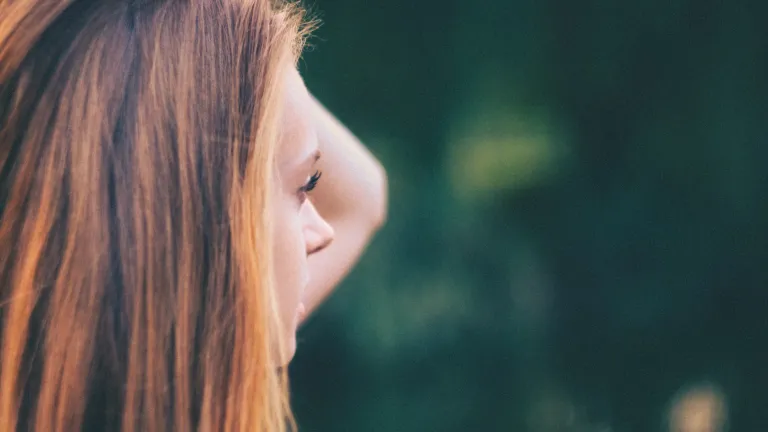 A woman looking with hand her hand by her head.