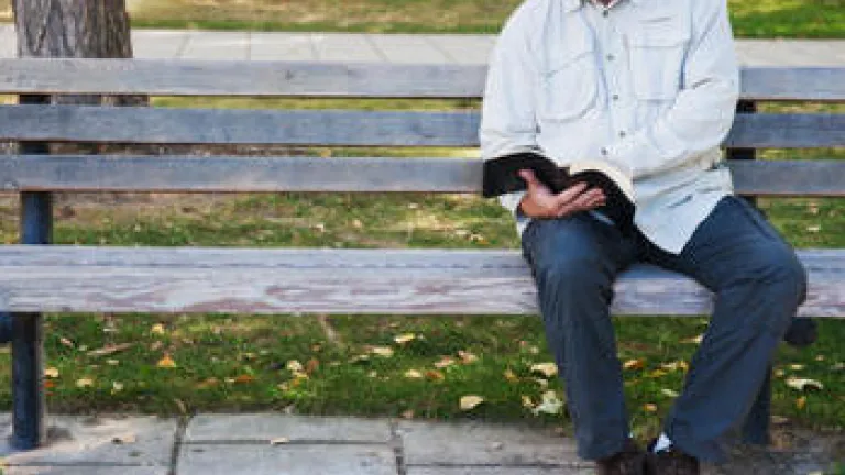 Transforming for Success A man sitting on a bench reaching the Bible.