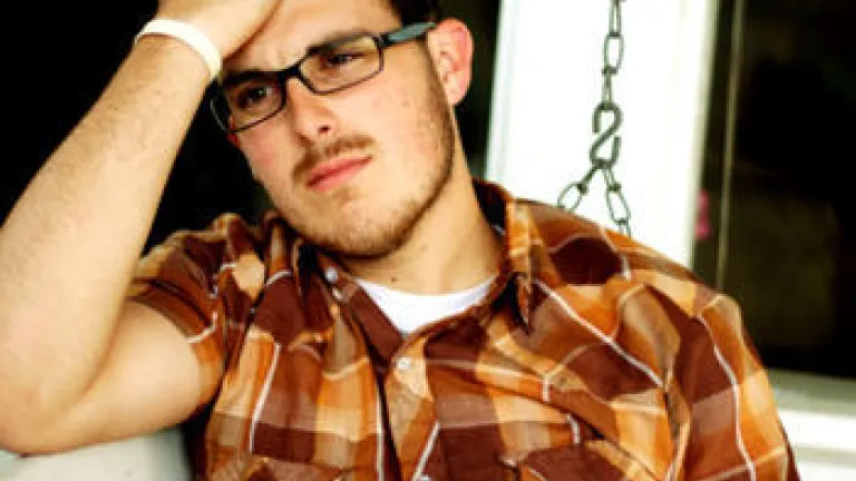 A sad looking young adult male with his hand on head.