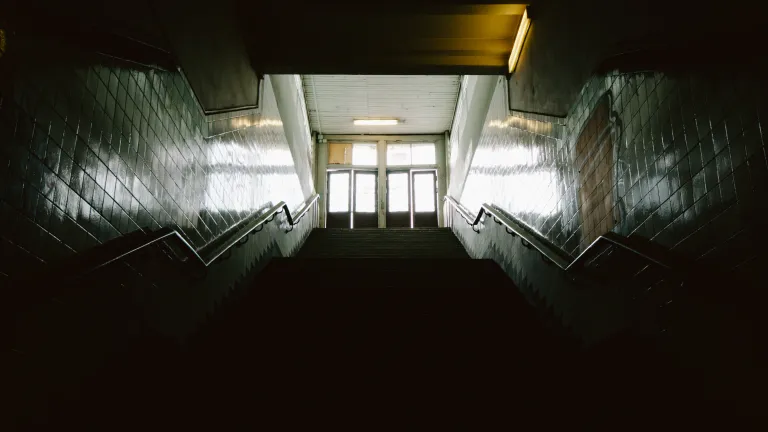 God sent Jesus to illuminate our paths into His home. Somehow humans find it easy to remain in the darkness. Dark stairs leading up to doors where light is coming through.