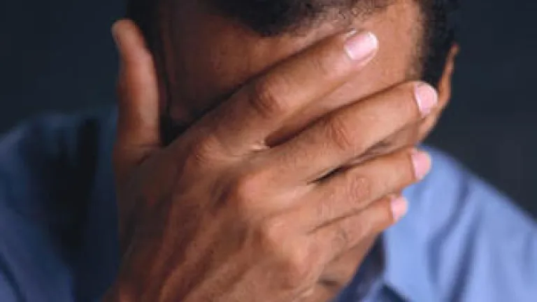 What do you do when someone suffers a major loss? A man with his hand over his face.