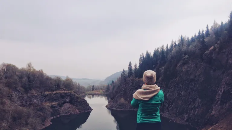 A young woman looking over a lake.