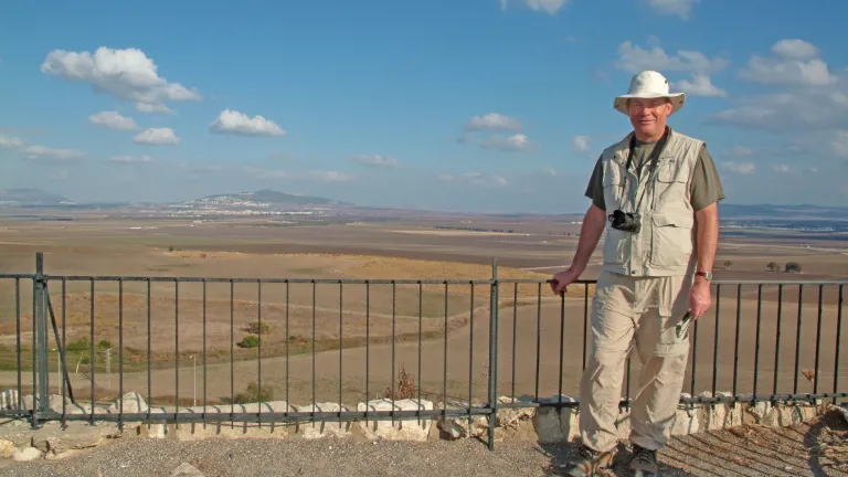 The author stands atop the hill of Megiddo—biblical Armageddon—overlooking the Jezreel Valley in northern Israel. The mountain in the background is the location of Nazareth, boyhood home of Jesus. Darris McNeely stands atop the hill of Megiddo.