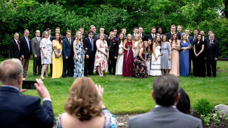 The class of 2019 smiles for a group photo with faculty after the graduation ceremony.