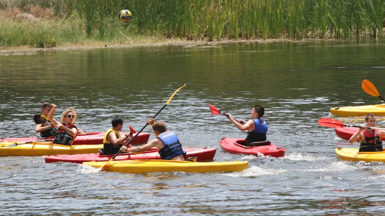 Campers kayak down the river.