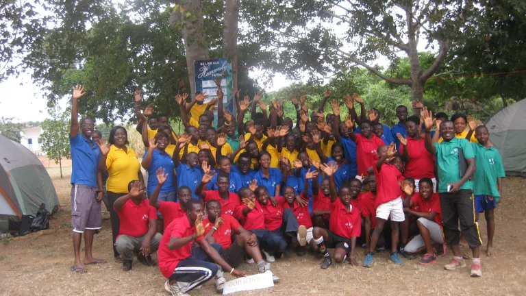 Campers and staff pose and wave at the camera.