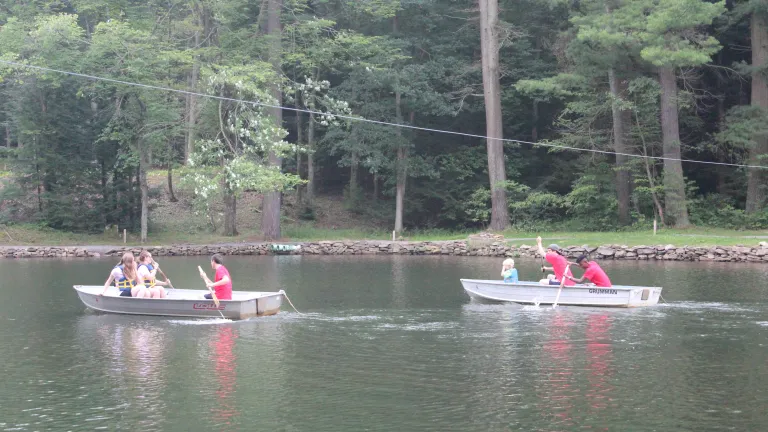 Campers in row boats on the river.