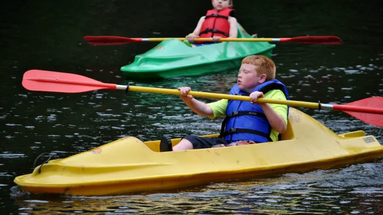 Campers canoe on the river at Camp Tomahawk.