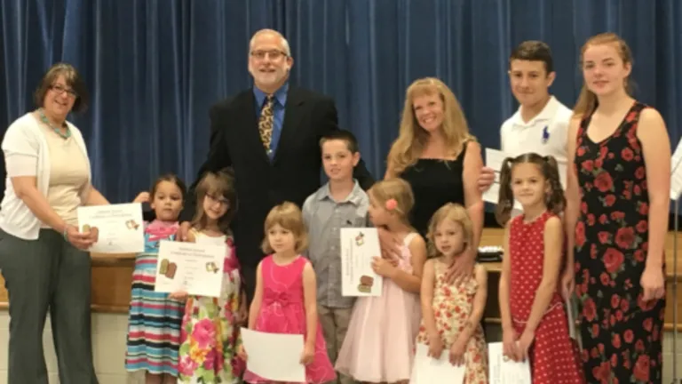 Scott Hoefker, minister of the Charlotte congregation, and Maria Petty, pose for a photo with the Sabbath school graduates.