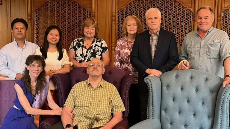 eight people standing and seated indoors