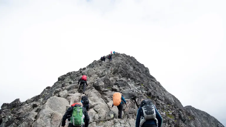Photo of a group hiking together up a mountain.