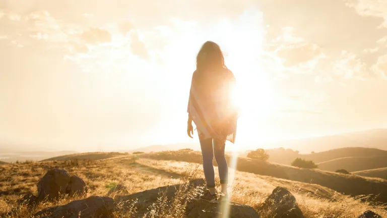 Photo of a person in a field at golden hour.