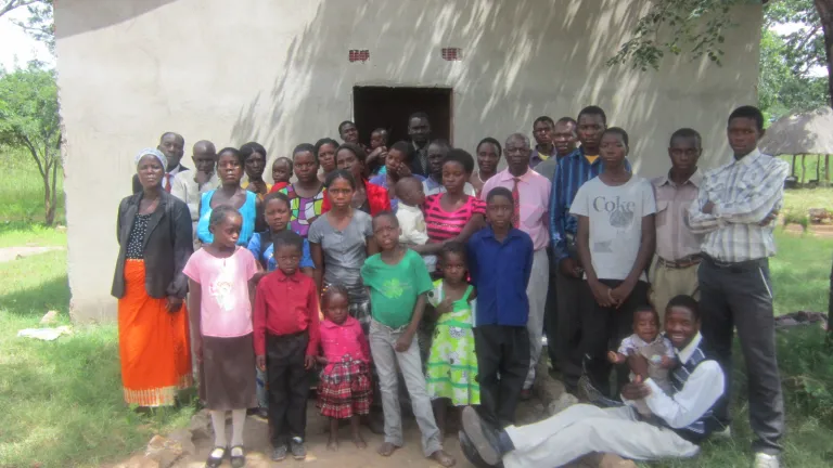A group shot of the congregation in Mapoko. Behind them is the church building the brethern built.