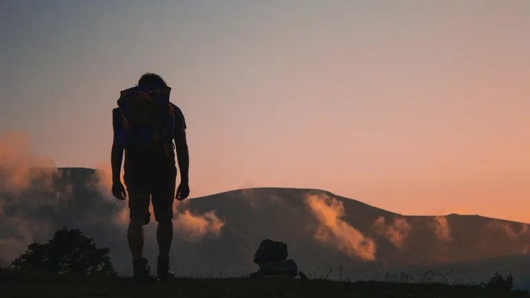 Photo of a man hiking at sunset.