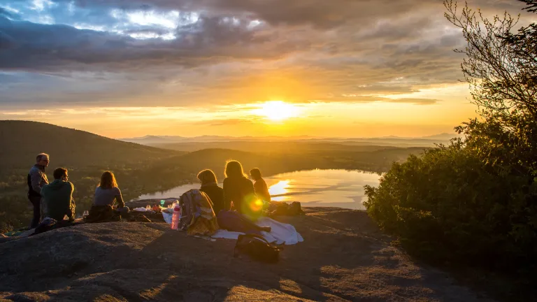 A group of people sitting on a hill.