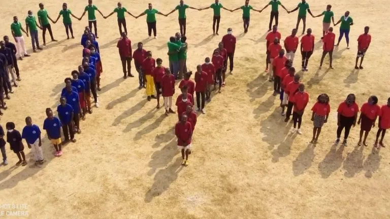 Photo of the youth at the camp in Zambia forming a UYC sign.