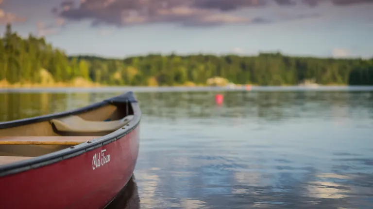 Photo of the bow of a canoe in a lake.