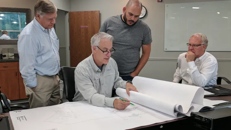 Peter Eddington and Rudy Rangel look at the new addition plans with Mark Bredemeier and Mike Barnard.