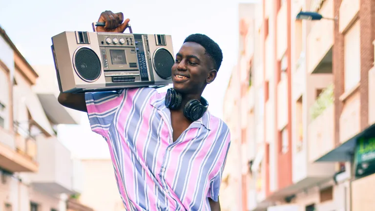 a teenager holding a vintage radio