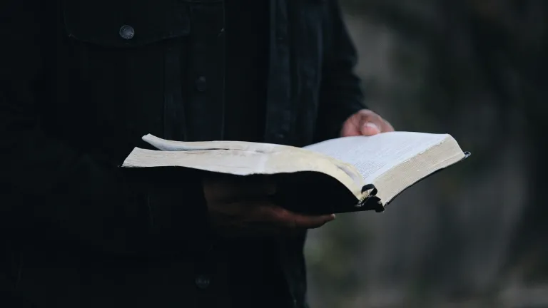 A man holding an open Bible.