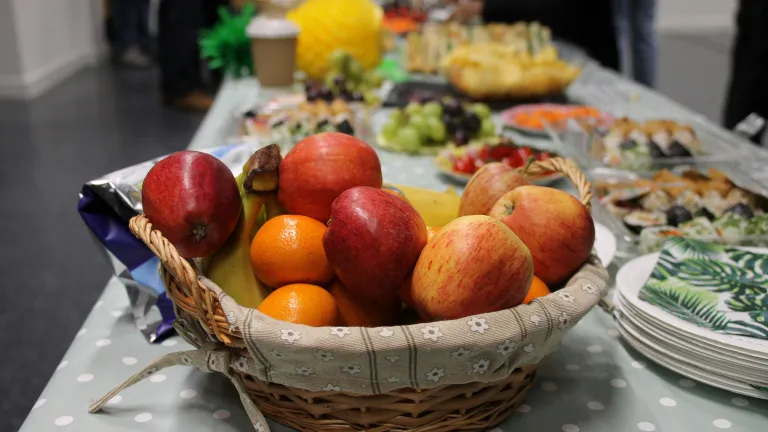 food on a table with a basket of fruit in the foreground