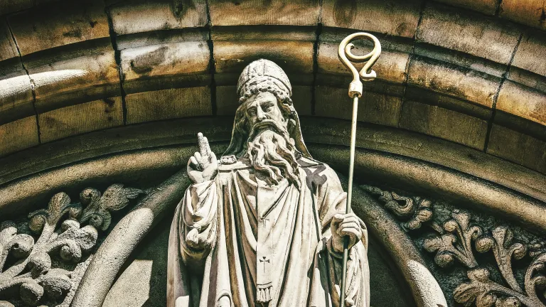 The real Patrick likely wouldn't even have approved of observing his own namesake holiday! a statue of St. Patrick outside a church archway