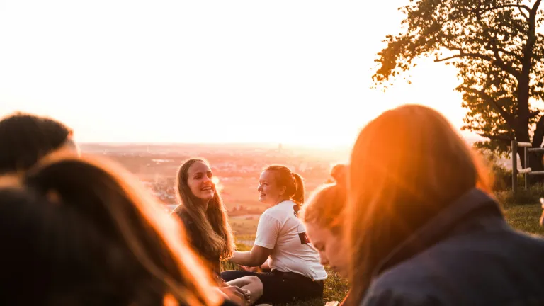 Group of friends talking at sunset