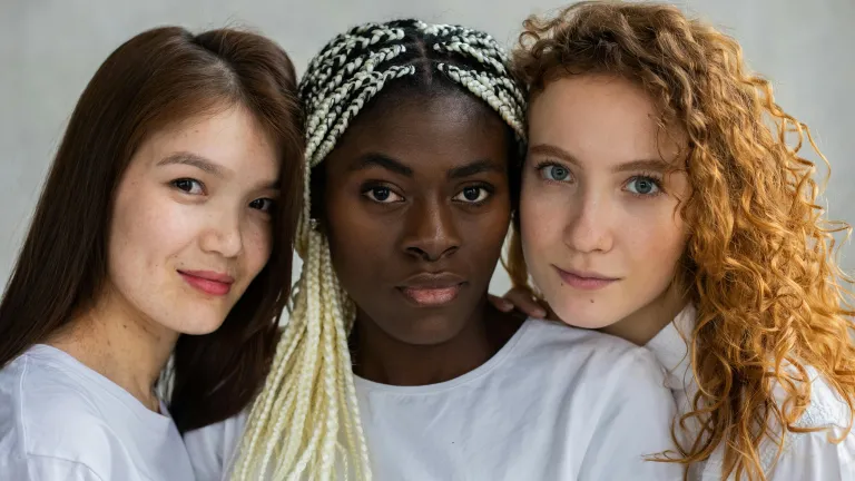 We need to build genuine loving and caring relationships in this multiracial, multinational and multicultural Church we are called to be part of. three women with differing skin tones