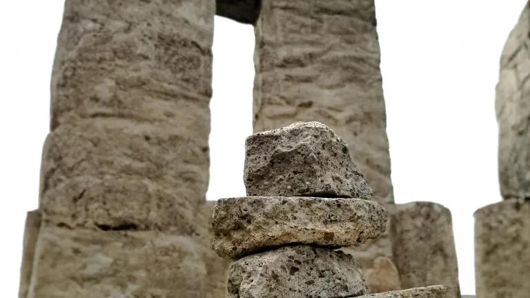 a stack of stones in front of an ancient ruined wall