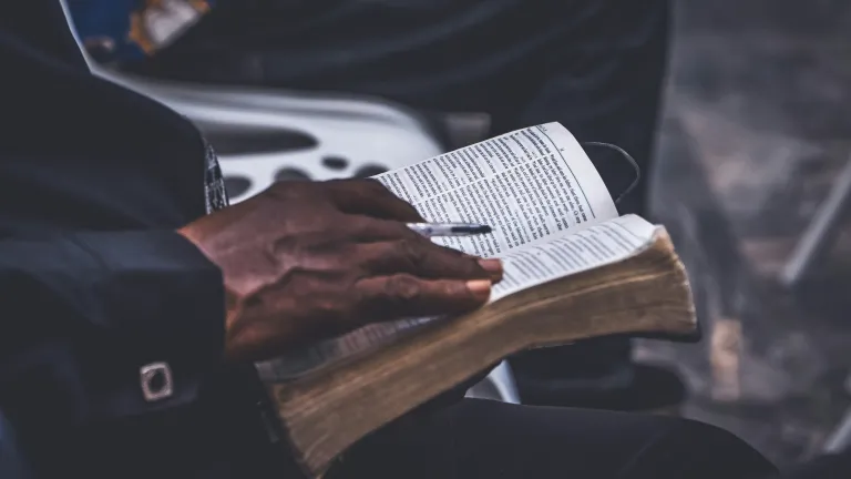 a man's hand on an open Bible