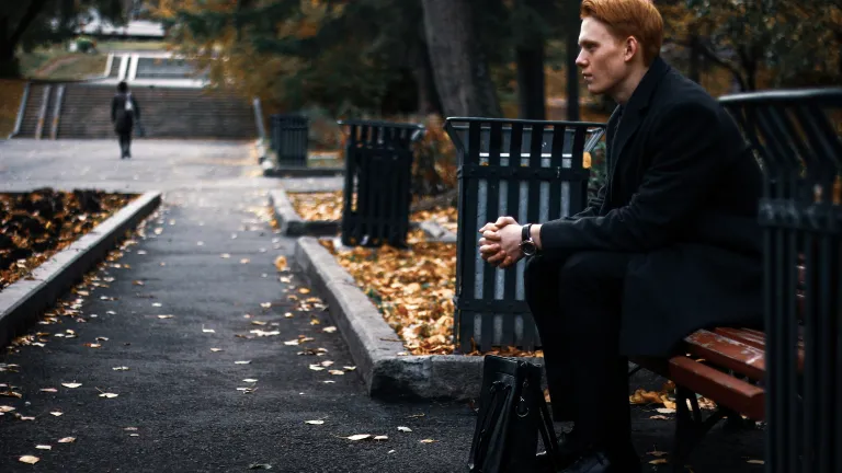 A man sitting on a park bench - thinking.