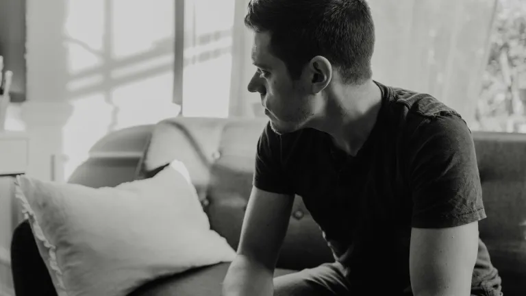 A man sitting on a couch looking away.