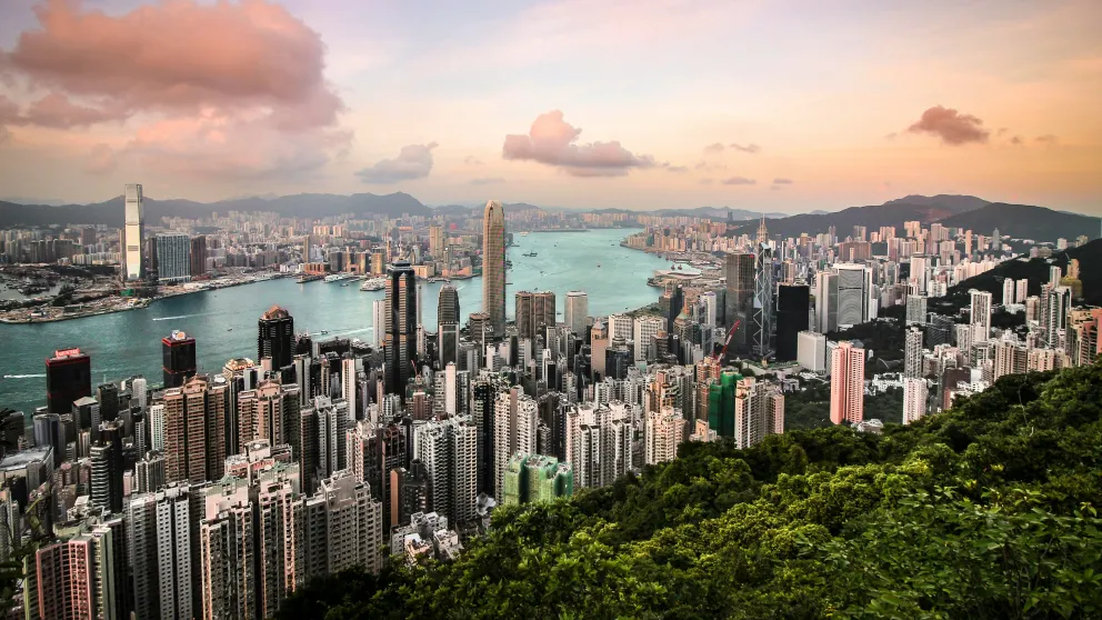 a city viewed from above with a river running between the two sides of the high-rise building landscape