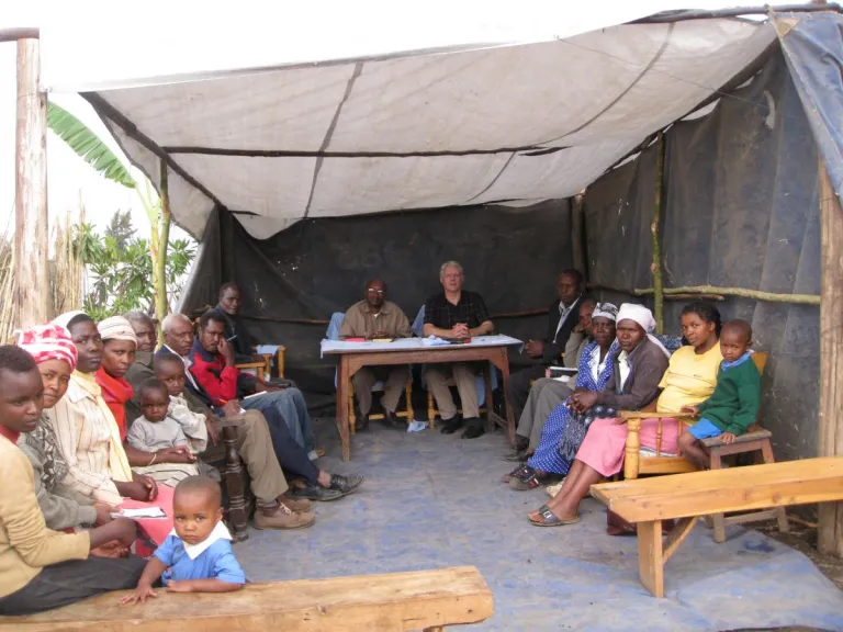 People in Kenya sitting under a tent for church services