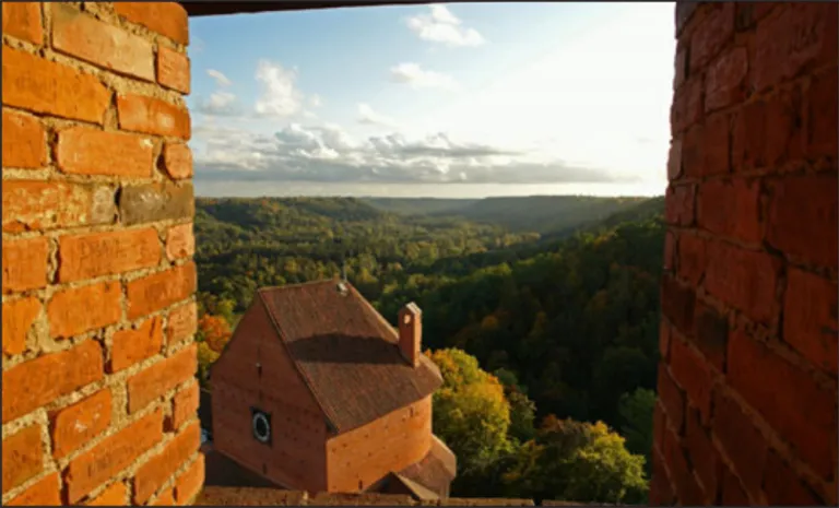 Photo through a brick window overlooking a valley