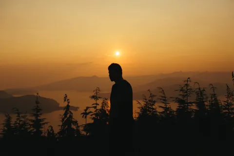 A man looking out over a lake.