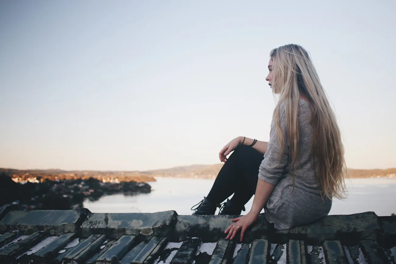 A women sitting looking out over water.