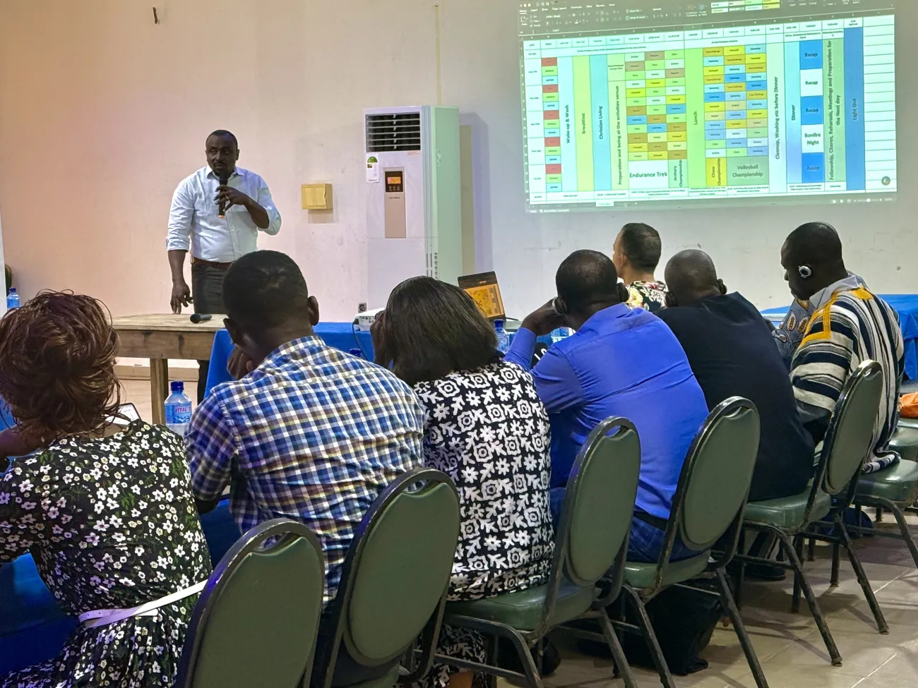 Man giving a presentation to a group of people at a long table