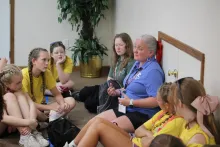 a group of teenage girls and a woman sitting in a circle