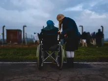 two people, one in a wheelchair, outside