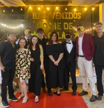 a group of people in formal wear standing at the end of a red carpet