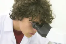 a man looking through a microscope